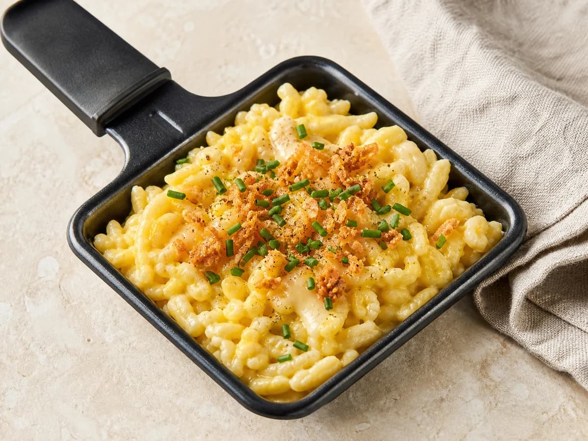 Käsespätzle-Pfännchen frisch zubereitet im Raclette-Pfännchen