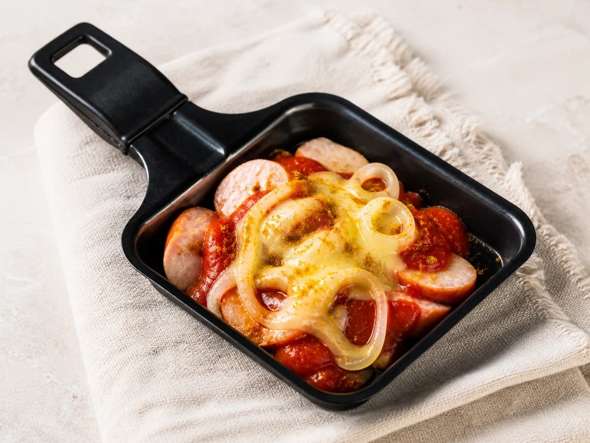 Currywurst-Pfännchen frisch zubereitet im Raclette-Pfännchen