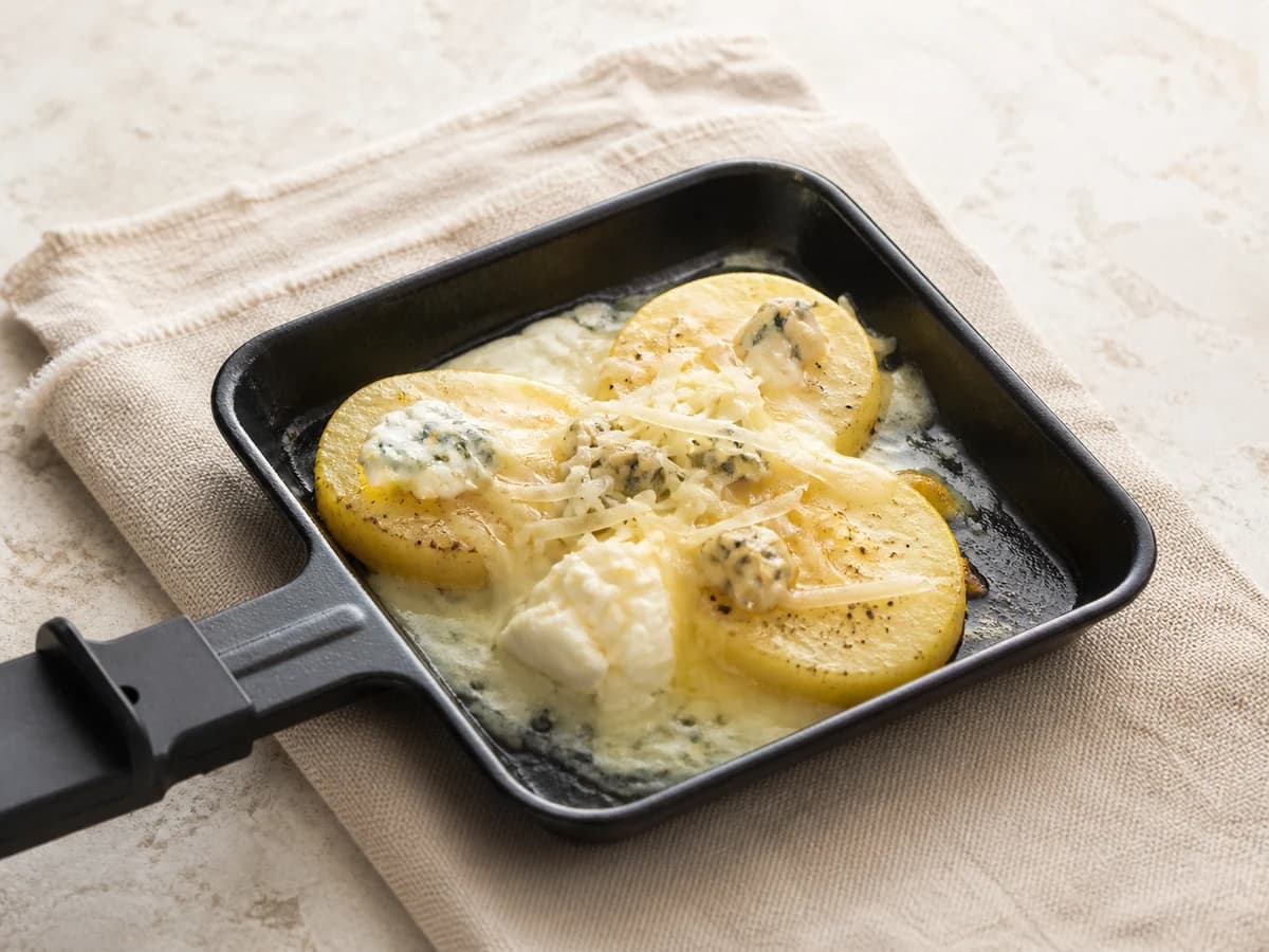 Vier-Käse-Pfännchen frisch zubereitet im Raclette-Pfännchen